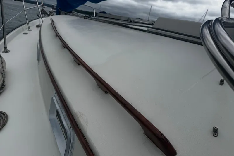 Slide: The Image of 1984 Nonsuch 26 Classic sailboat deck with wooden handrails and metal fittings. - 6
