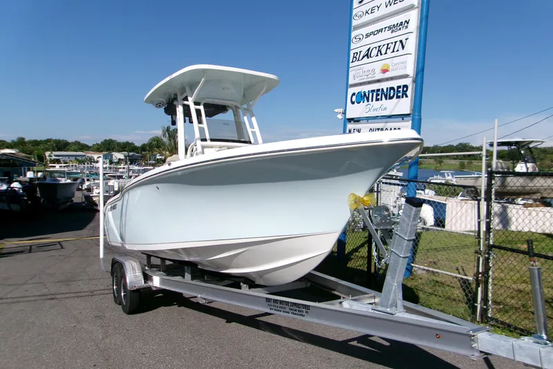 Slide: The Image of 2026 Key West 239 FS boat on trailer at dealership, clear sky background. - 17