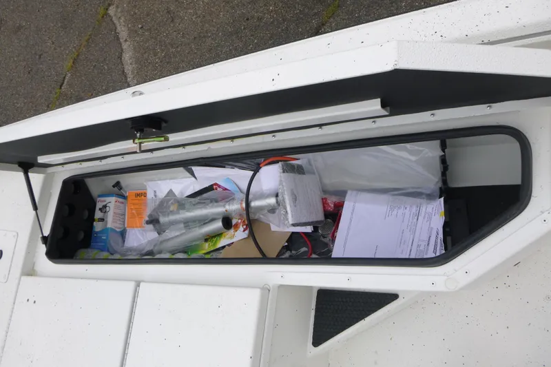 Slide: The Image of Storage compartment of 2025 Ranger RB210 boat filled with various items and documents. - 8