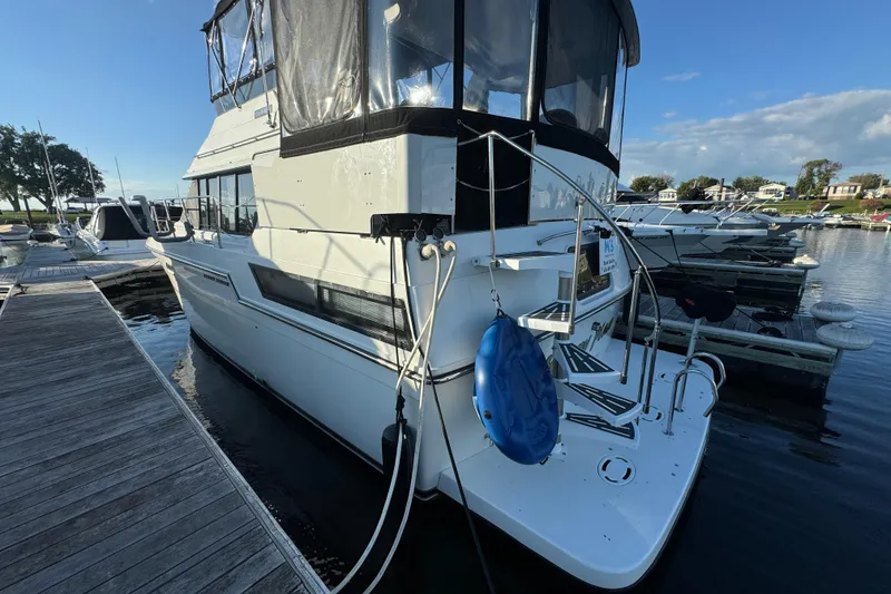 Slide: The Image of 1990 Carver 3807 Aft Cabin yacht docked at marina under clear blue sky. - 16