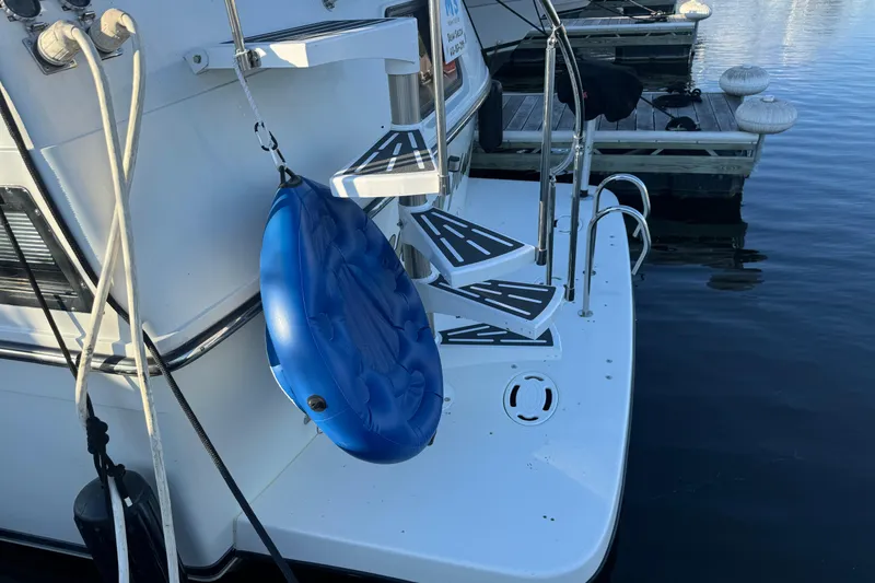 Slide: The Image of 1990 Carver 3807 Aft Cabin boat with blue inflatable tube at dock. - 18