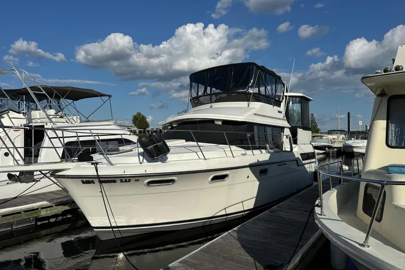 Slide: The Image of 1990 Carver 3807 Aft Cabin yacht docked at marina under blue sky. - 19