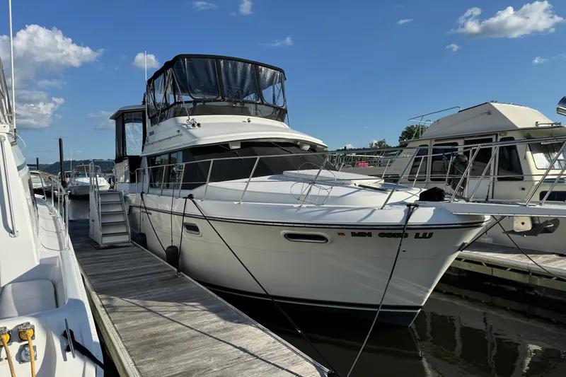 Slide: The Image of 1990 Carver 3807 Aft Cabin yacht docked at marina under clear blue sky. - 21