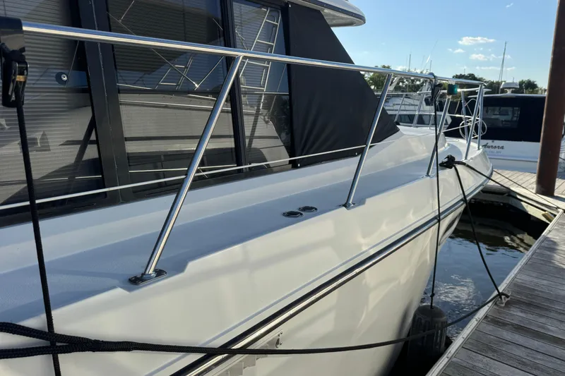 Slide: The Image of 1990 Carver 3807 Aft Cabin yacht docked, featuring sleek railings and modern design. - 26