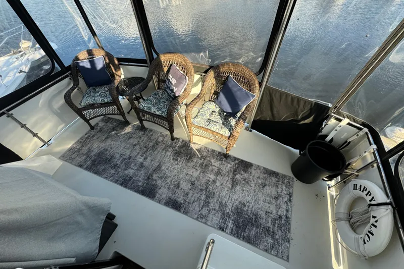 Slide: The Image of 1990 Carver 3807 Aft Cabin interior with wicker chairs, cushions, and a rug. - 28