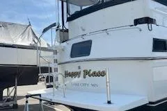 Slide: The Image of 1990 Carver 3807 Aft Cabin yacht docked, featuring "Happy Place" on the stern. - 3