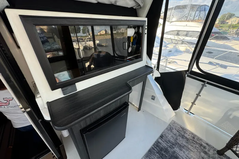 Slide: The Image of 1990 Carver 3807 Aft Cabin interior with kitchenette and marina view. - 30