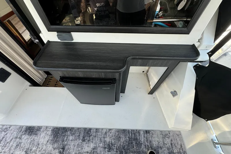 Slide: The Image of 1990 Carver 3807 Aft Cabin interior with compact fridge and sleek countertop design. - 32