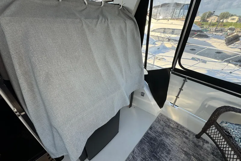 Slide: The Image of 1990 Carver 3807 Aft Cabin interior with covered furniture and marina view. - 33