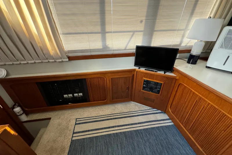 Slide: The Image of 1990 Carver 3807 Aft Cabin interior with TV, lamp, and striped rug. - 39