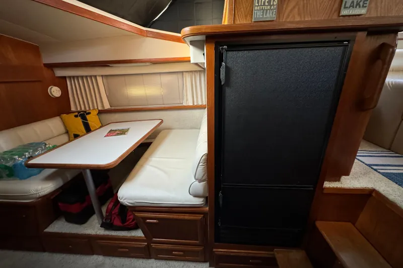 Slide: The Image of 1990 Carver 3807 Aft Cabin interior with dining area, table, and cushioned seating. - 41