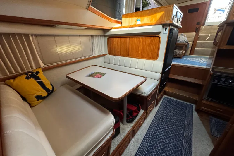 Slide: The Image of 1990 Carver 3807 Aft Cabin interior with cozy dining area and nautical decor. - 46