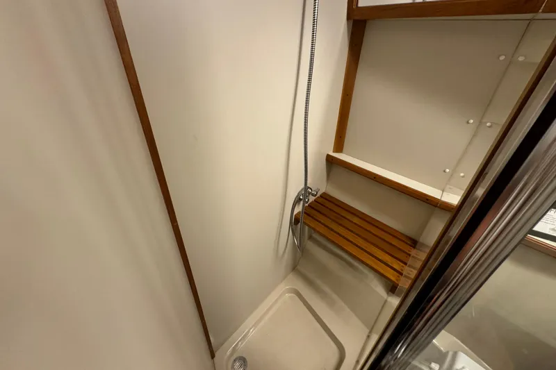 Slide: The Image of Shower area in 1990 Carver 3807 Aft Cabin with wooden bench and handheld showerhead. - 49
