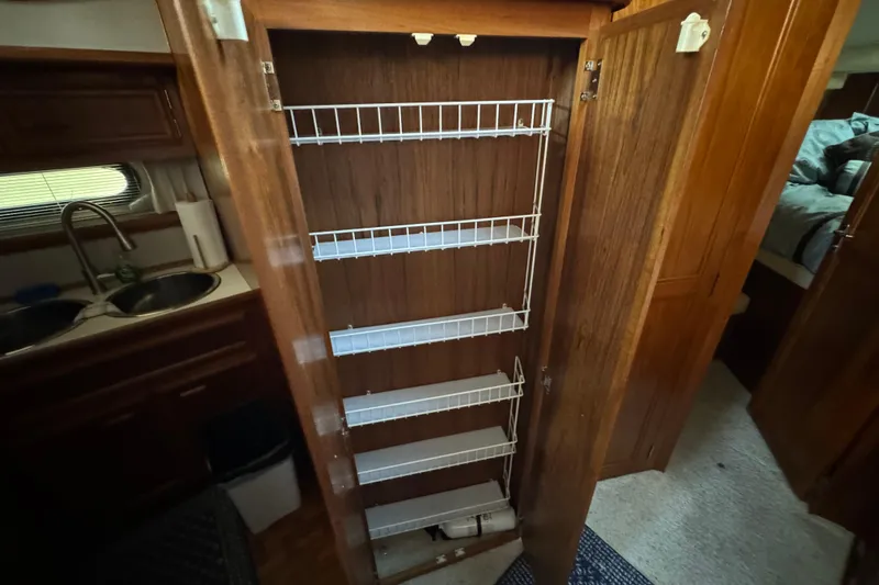 Slide: The Image of 1990 Carver 3807 Aft Cabin interior with open pantry and wire shelving. - 50