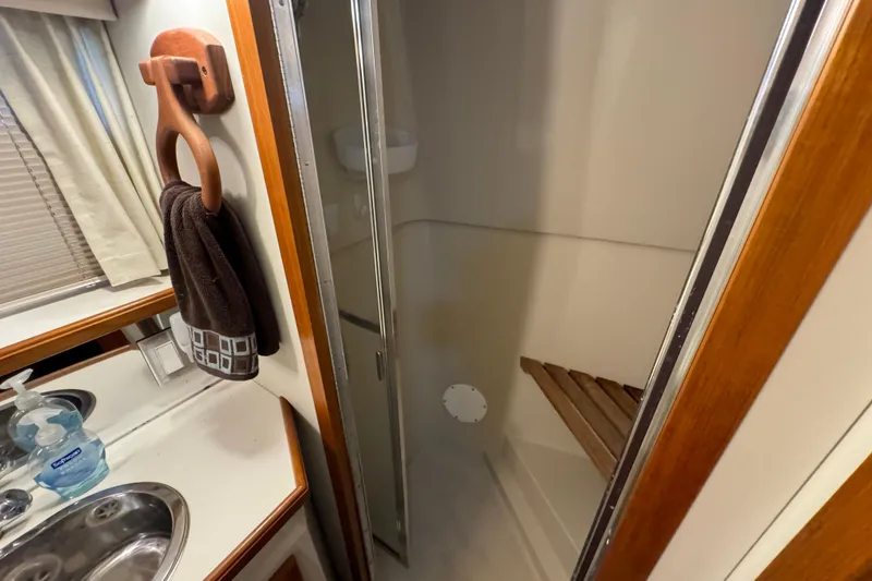 Slide: The Image of 1990 Carver 3807 Aft Cabin bathroom with sink, shower, and towel rack. - 54