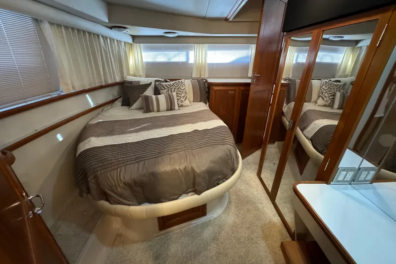 Slide: The Image of 1990 Carver 3807 Aft Cabin interior with cozy bed, wood accents, and mirrored closet. - 55