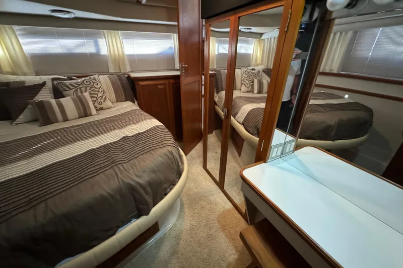Slide: The Image of 1990 Carver 3807 Aft Cabin interior with cozy bed, mirrored closet, and elegant decor. - 56