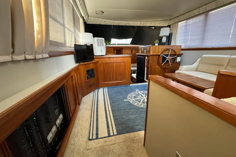 Slide: The Image of Luxurious interior of 1990 Carver 3807 Aft Cabin yacht with wood accents and cozy seating. - 59