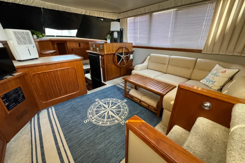 Slide: The Image of 1990 Carver 3807 Aft Cabin interior with cozy seating, nautical decor, and wooden accents. - 60