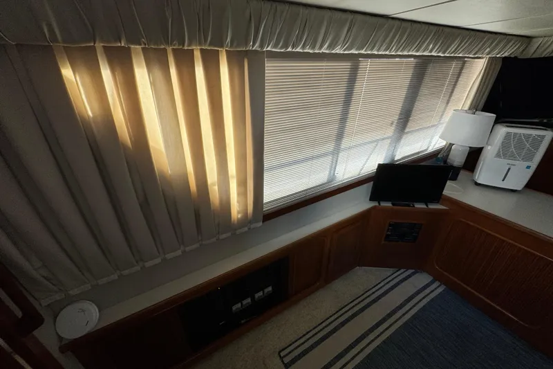 Slide: The Image of Interior of 1990 Carver 3807 Aft Cabin with curtains, lamp, and small TV. - 61