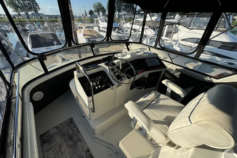 Slide: The Image of Interior view of 1990 Carver 3807 Aft Cabin yacht helm with marina background. - 63