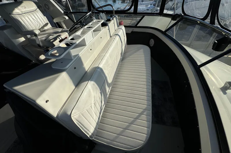 Slide: The Image of 1990 Carver 3807 Aft Cabin interior with white seating and helm station. - 69