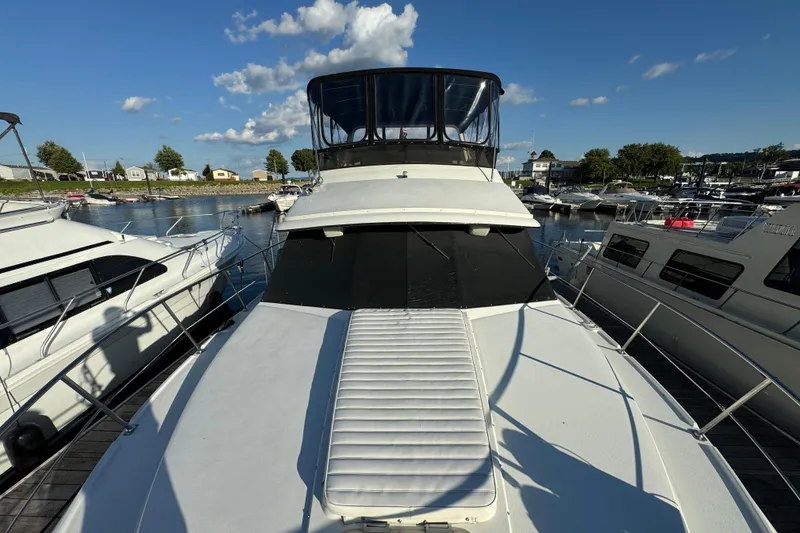 Slide: The Image of 1990 Carver 3807 Aft Cabin yacht docked at marina under clear blue sky. - 7