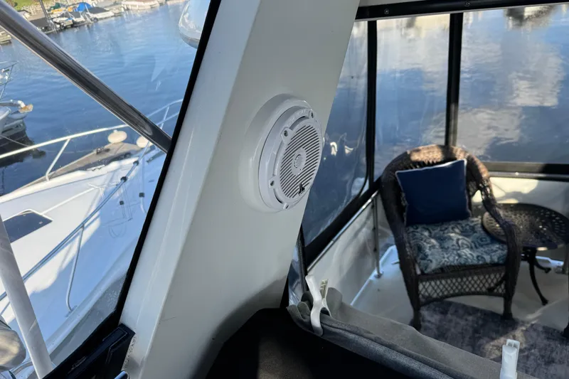 Slide: The Image of 1990 Carver 3807 Aft Cabin interior with speaker and wicker chair by the window. - 71