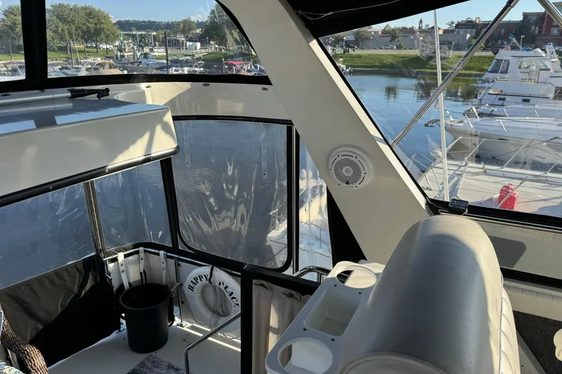 Slide: The Image of 1990 Carver 3807 Aft Cabin interior with marina view, featuring seating and life preserver. - 72