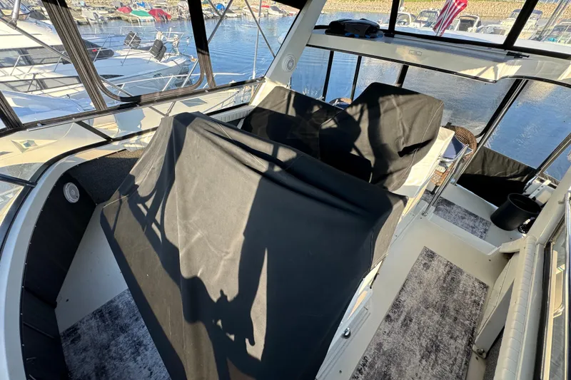 Slide: The Image of 1990 Carver 3807 Aft Cabin interior with covered seating, docked at marina. - 76