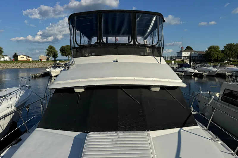Slide: The Image of 1990 Carver 3807 Aft Cabin yacht docked at marina under clear blue sky. - 8