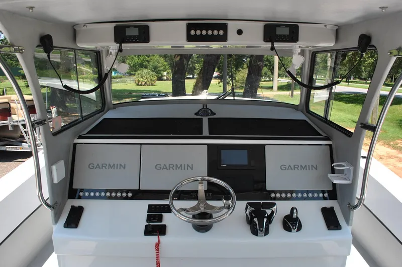 Slide: The Image of 2024 TomCat 36 boat cockpit with Garmin navigation systems and modern controls. - 12