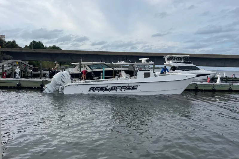 Slide: The Image of 2024 TomCat 36 boat named "Reel Office" docked near a bridge. - 17