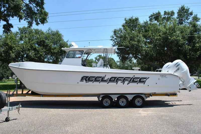 Slide: The Image of 2024 TomCat 36 boat on trailer, featuring "Reel Office" branding, parked outdoors. - 3