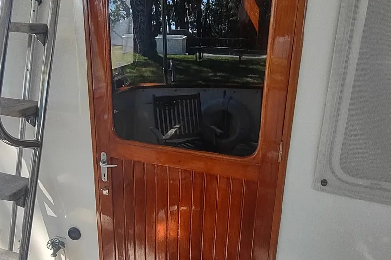 Slide: The Image of Wooden door on 2001 Kadey-Krogen 39 boat, with ladder and window reflection. - 19