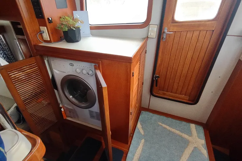 Slide: The Image of Interior of 2001 Kadey-Krogen 39 yacht with washing machine and wooden cabinetry. - 41