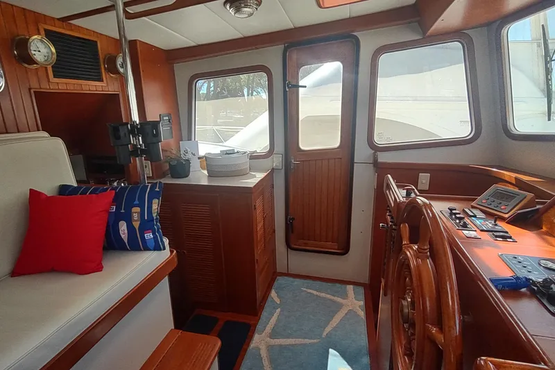 Slide: The Image of Interior of 2001 Kadey-Krogen 39 yacht with wooden helm and cozy seating area. - 42