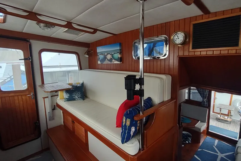 Slide: The Image of Interior of 2001 Kadey-Krogen 39 yacht with wooden paneling and cozy seating area. - 56