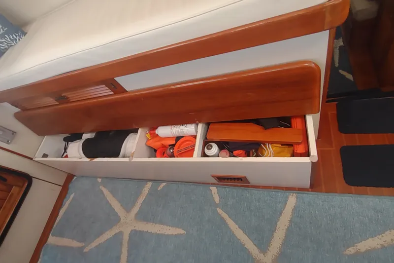 Slide: The Image of Storage compartment in a 2001 Kadey-Krogen 39 boat, containing various boating essentials. - 58