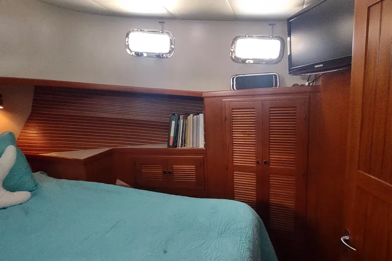 Slide: The Image of Cozy cabin interior of 2001 Kadey-Krogen 39 yacht with wood paneling and teal bedding. - 64