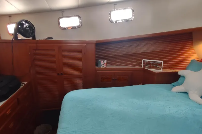 Slide: The Image of Cozy cabin interior of 2001 Kadey-Krogen 39 with wooden accents and blue bedding. - 65