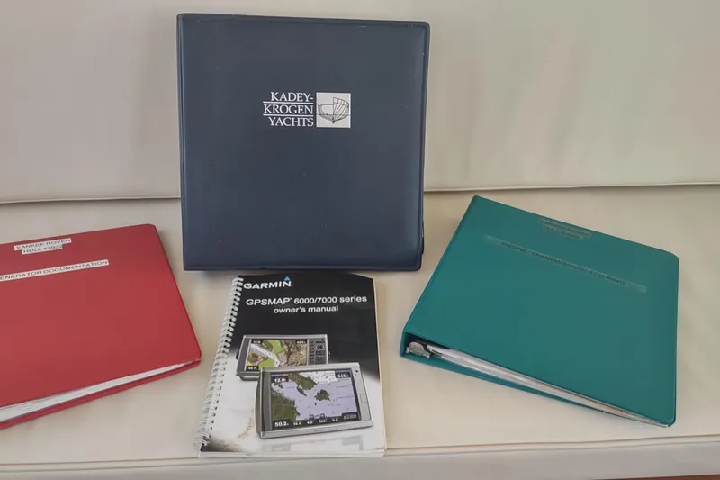 Slide: The Image of Binders and manuals for Kadey-Krogen 39 yacht, including Garmin GPSMAP owner's manual. - 86