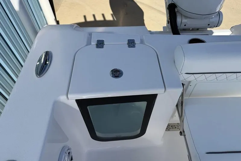 Slide: The Image of 2026 Sportsman Open 232 Center Console boat interior, featuring seating and storage compartment. - 21