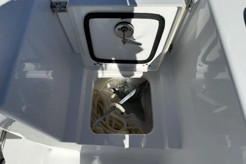 Slide: The Image of 2026 Sportsman Open 232 Center Console anchor storage with rope and anchor visible. - 22
