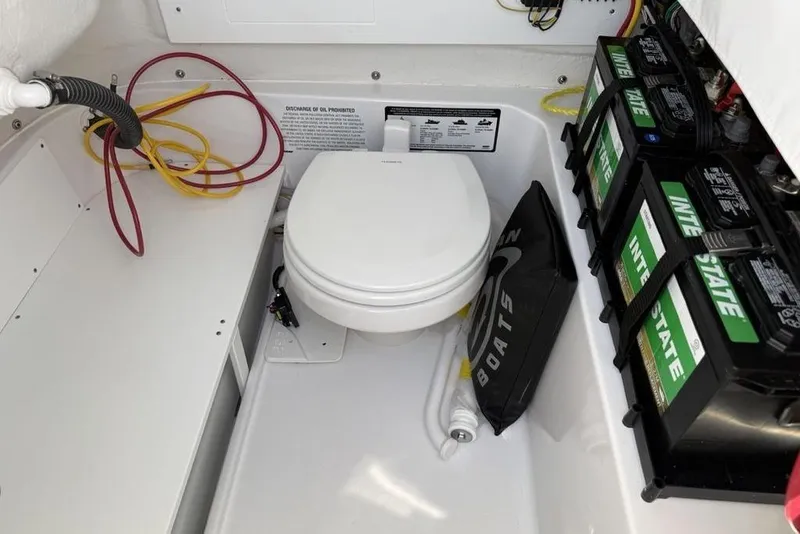 Slide: The Image of 2026 Sportsman Open 232 Center Console boat interior with toilet and batteries. - 33