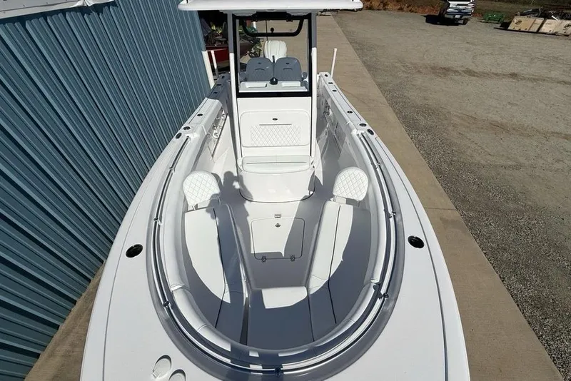 Slide: The Image of 2026 Sportsman Open 232 Center Console boat, white interior, docked beside a blue building. - 37