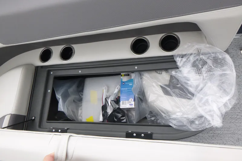 Slide: The Image of Storage compartment in 2026 Sun Tracker Bass Buggy 18 DLX boat, featuring cup holders and accessories. - 10