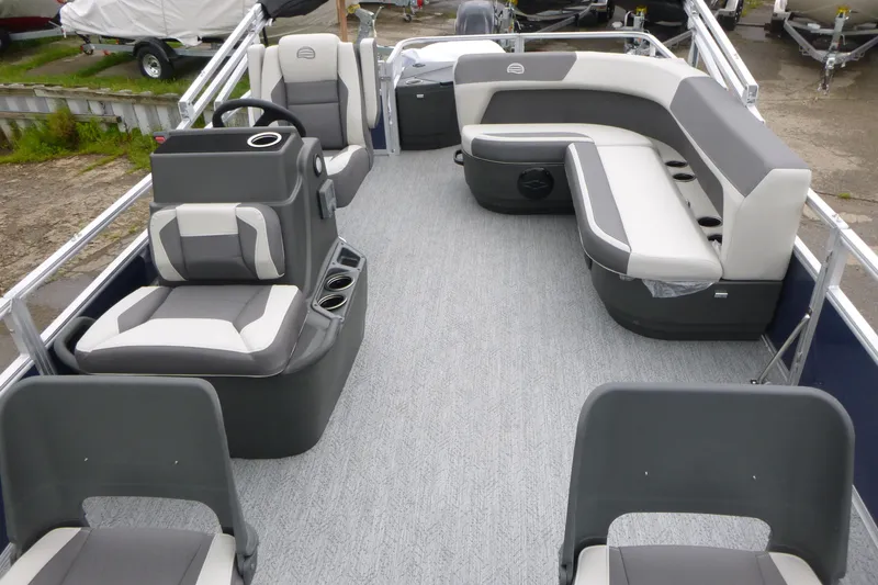 Slide: The Image of 2026 Sun Tracker Bass Buggy 18 DLX pontoon boat interior with gray seating and steering console. - 4