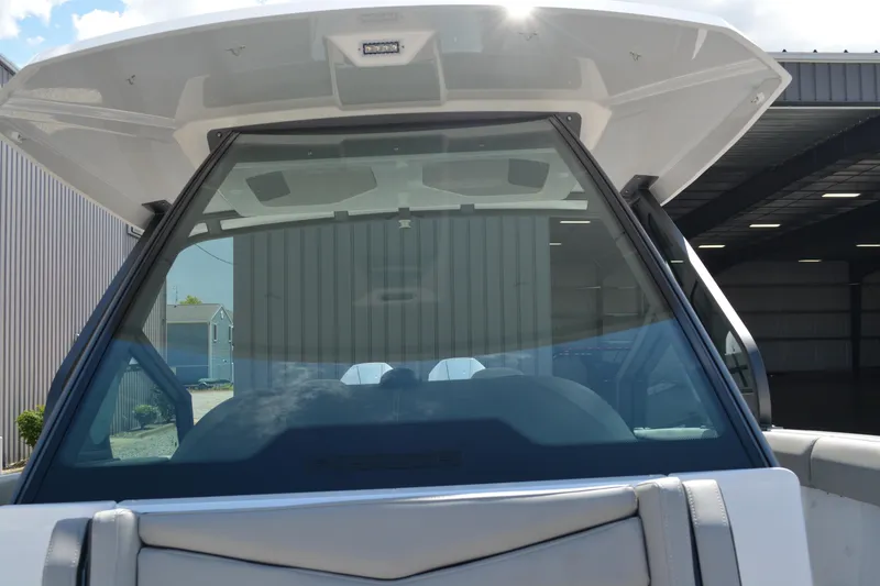 Slide: The Image of 2026 Monterey Elite 30 OB boat with sleek windshield design in a marina setting. - 12