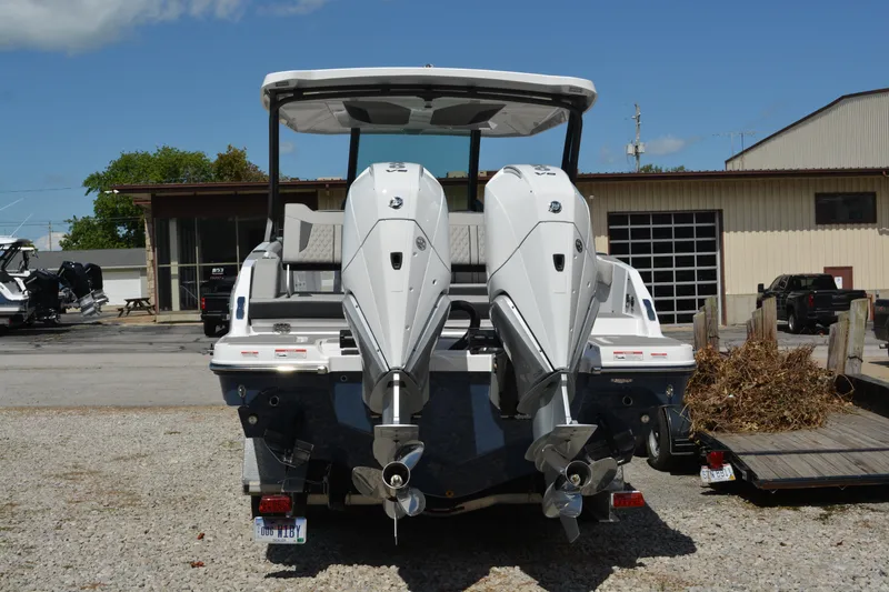 Slide: The Image of 2026 Monterey Elite 30 OB boat with dual outboard engines, parked outdoors. - 3